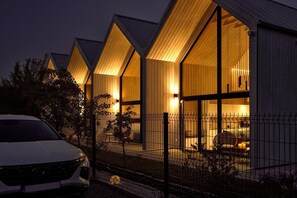 A row of modern, well-lit buildings with large windows and a fenced outdoor area. - Luxury holiday homes near the beach, Mielno (Mielno)