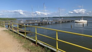 A marina with docks and boats, a yellow safety railing, and a clear sky. - Comfortable 2-room apartments close to the beach (Mielno)