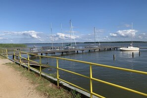 Een jachthaven met steigers en boten, een gele veiligheidsreling en een heldere lucht.