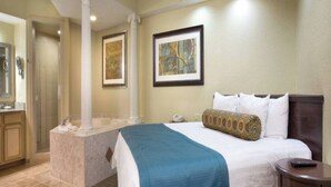 A hotel room with a large bed, a separate bathroom with a shower, and a small table. - Luxury 3BR Resort Villa w/ Jacuzzi Near Disney (Kissimmee)