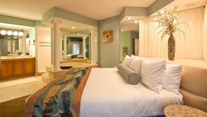A hotel room with a bed, a vanity with a mirror, a vase with flowers, and a view of the outside. - Luxury 3BR Resort Villa w/ Jacuzzi Near Disney (Kissimmee)