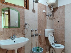 Un baño con lavamanos, inodoro y ducha.