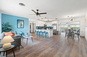 Ein modernes Wohnzimmer mit Sofa, Couchtisch und einem Essbereich mit Stühlen.