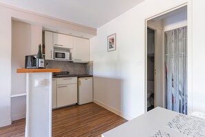 A compact kitchen with a microwave, a small refrigerator, and a wooden countertop. - La Pause courseullaise - Joli studio proche plage (Courseulles-sur-Mer)