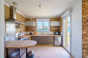 Eine kompakte Küche mit einer zentralen Kochinsel, einem eingebauten Backofen und einem Geschirrspüler.