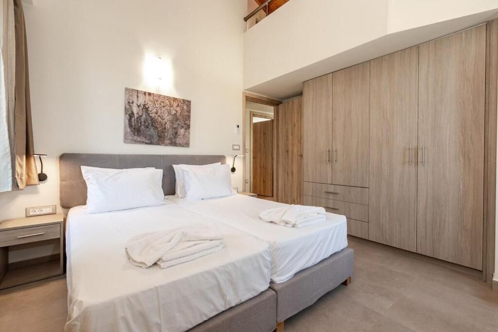 A bedroom with a bed, bedside tables, a wardrobe, and a painting on the wall.