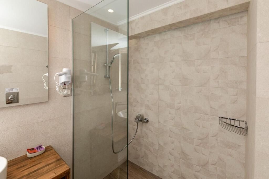 Ein modernes Badezimmer mit Duschkabine aus Glas, einem Holzwaschtisch und einem wandmontierten Handtuchhalter.