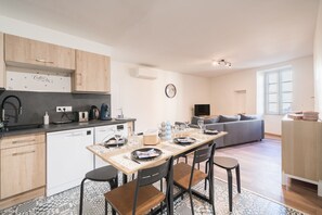 Una cucina moderna con zona pranzo, divano e televisione in soggiorno.