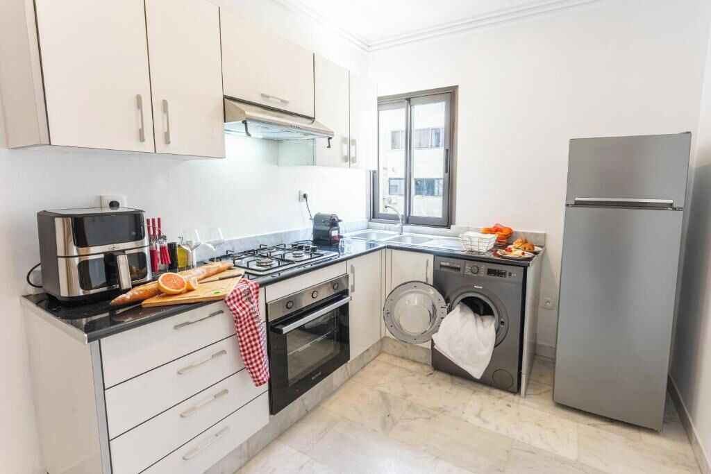 A compact kitchen with a gas stove, oven, microwave, and a washing machine.