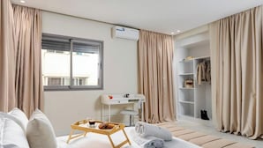 Ein Hotelzimmer mit Bett, Schreibtisch, Kleiderschrank und Fenster.