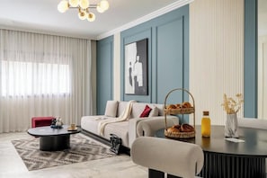 A modern living room with a sofa, coffee table, and a wall-mounted artwork. - The Loft  (Casablanca)