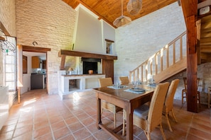 Un intérieur rustique comprenant un coin repas, une cuisine et un escalier.