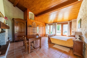 Ein Zimmer mit Holzausstattung, einem Bett, einem Tisch und einem Kamin.