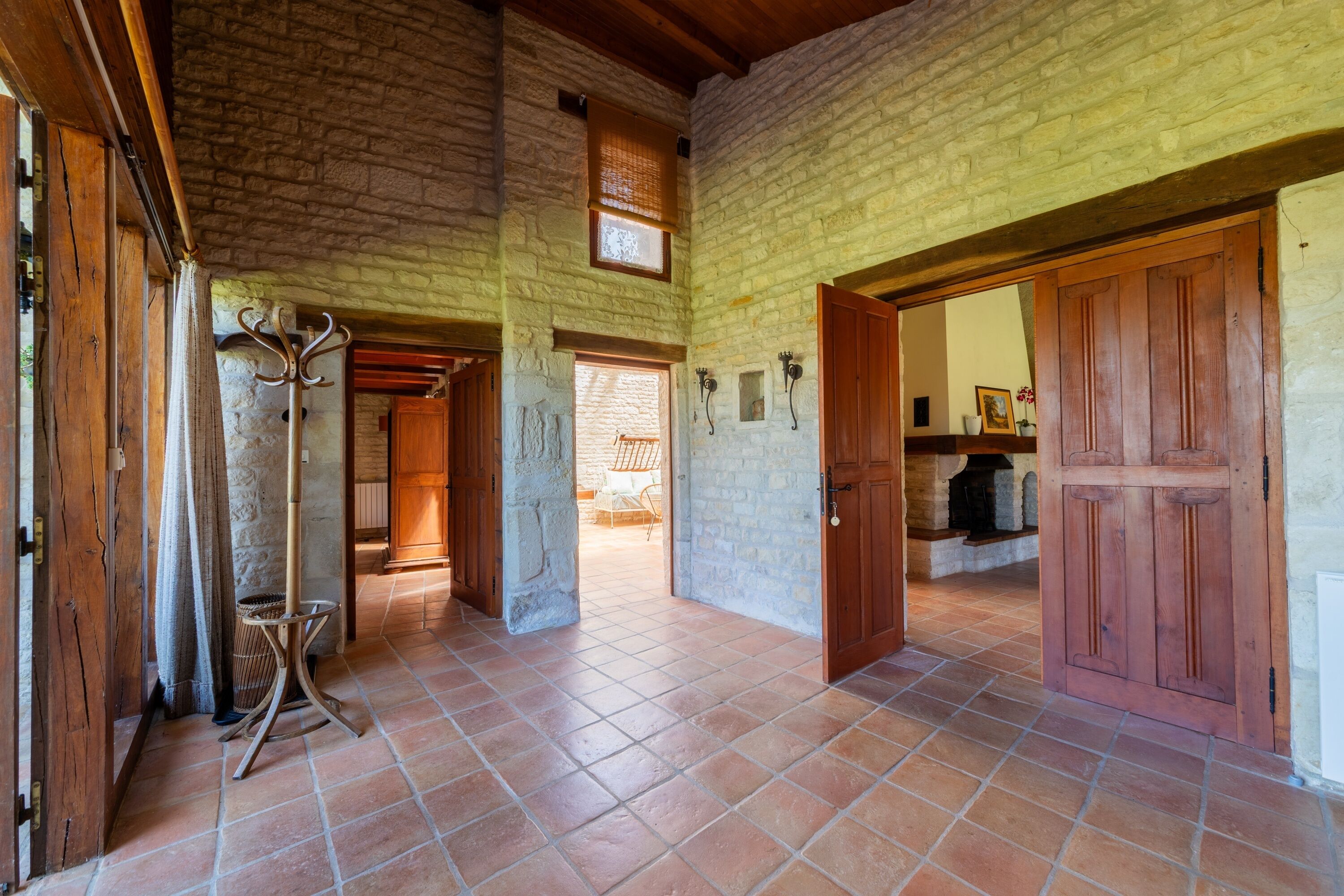 Un intérieur spacieux avec un plafond haut, des murs en pierre et un sol carrelé.