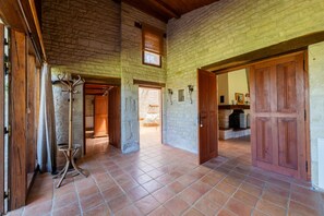 Un intérieur spacieux avec un plafond haut, des murs en pierre et un sol carrelé.