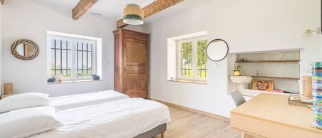 A room with a bed, a wooden table, and a window with a view.