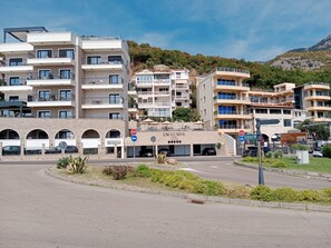 Ein mehrstöckiges Hotel mit Balkonen, einer Tiefgarage und einem Schild, das eine Distanz von 1 Kilometer anzeigt.