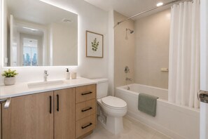 Ein modernes Badezimmer mit Toilette, Waschbecken und Badewanne.