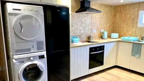 A laundry area with a washer and dryer, a stove, and a sink. - Yurt with Private Hot Tub and Bathroom (Bridport)