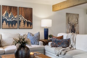 A living room with a sofa, a coffee table, a lamp, and wall art. - Outpost: Teton Shadows Wister H - Teton Views! (Jackson)
