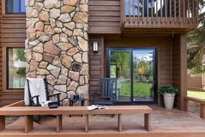 A wooden deck with a stone pillar, a bench, and a chair. - Outpost: Teton Shadows Wister H - Teton Views! (Jackson)
