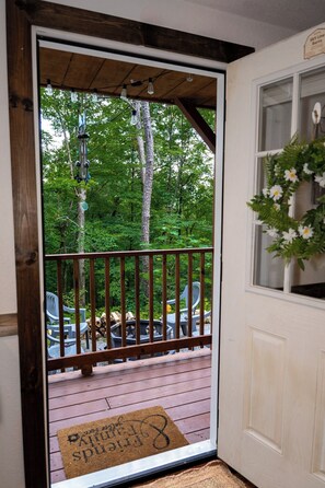 A wooden deck with a metal railing, a fire pit, and outdoor seating. - Sweet Serenity Cabin Dunlap Tennessee (Dunlap)