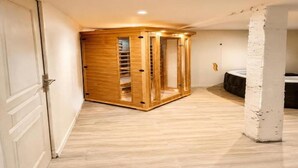 Una habitación en esquina con un armario de madera, una puerta blanca y un pilar de ladrillo blanco.