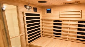 Una sala de sauna con bancos de madera y un panel de control.