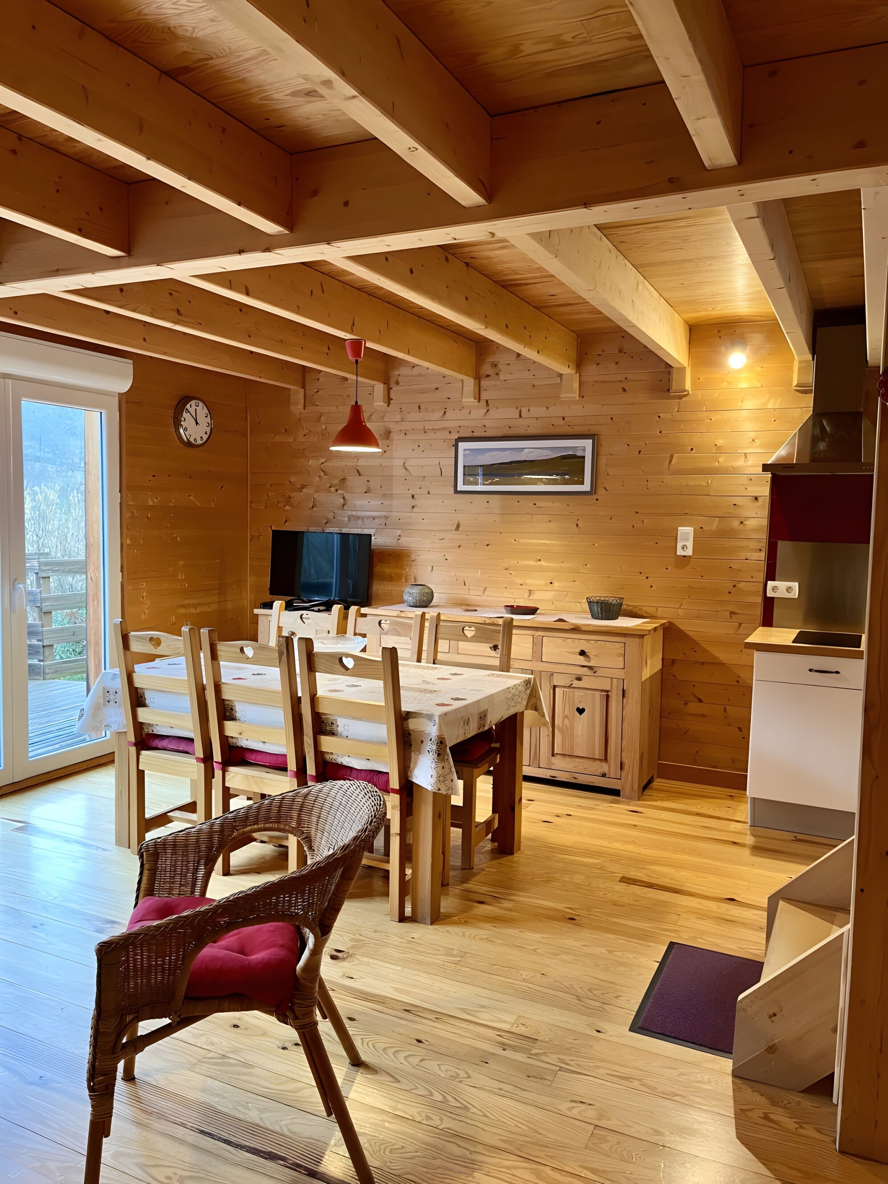 Un interior de madera con comedor, cocina y escalera.
