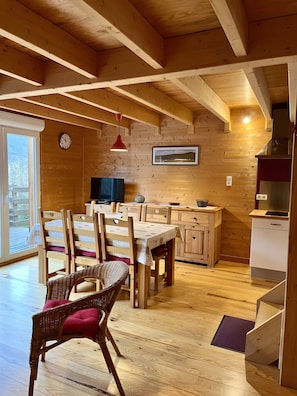 Un intérieur en bois comprenant un coin repas, une cuisine et un escalier.