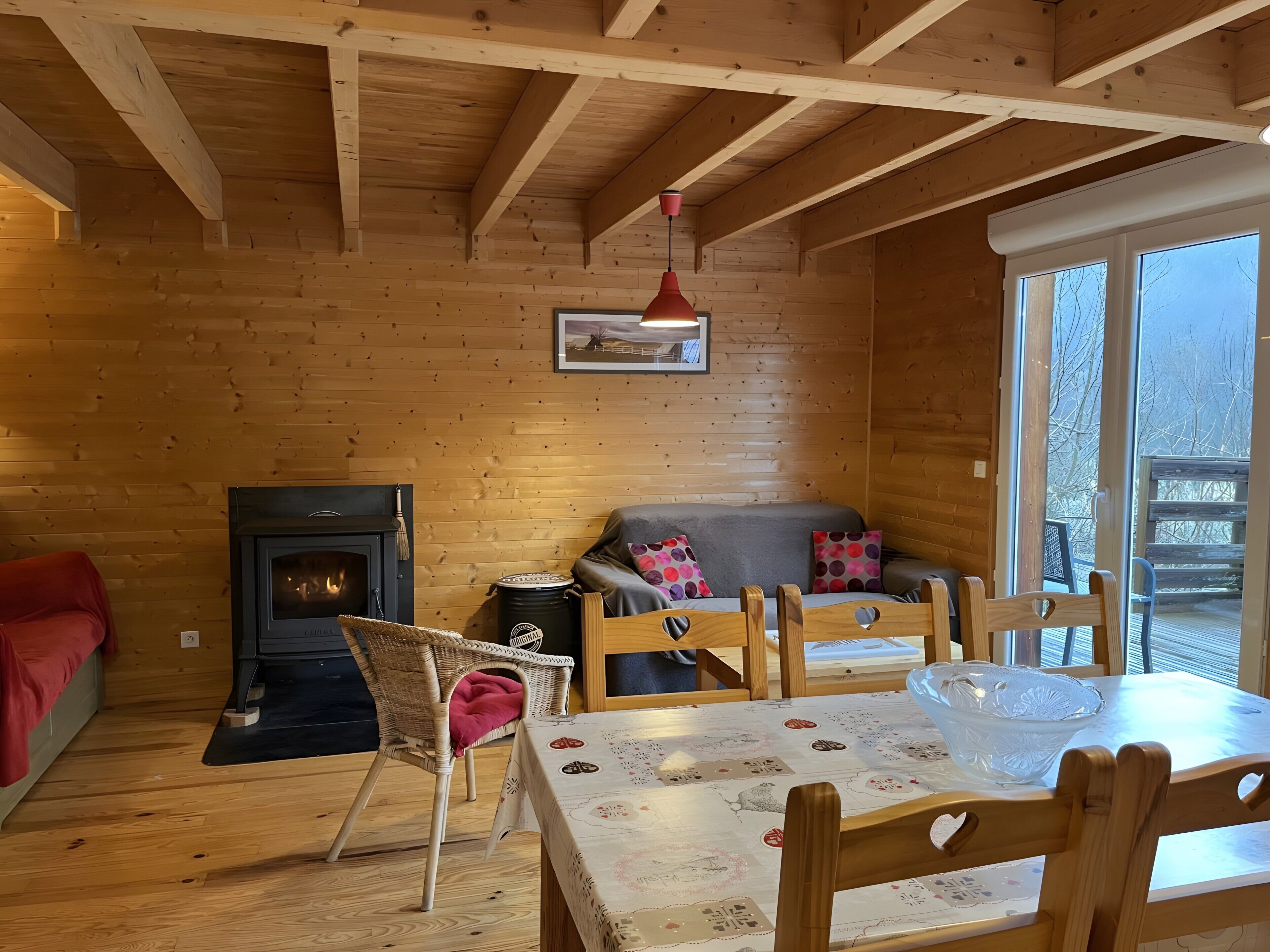 Ein gemütliches Blockhaus-Interieur mit Kamin, Holzmöbeln und großen Fenstern.