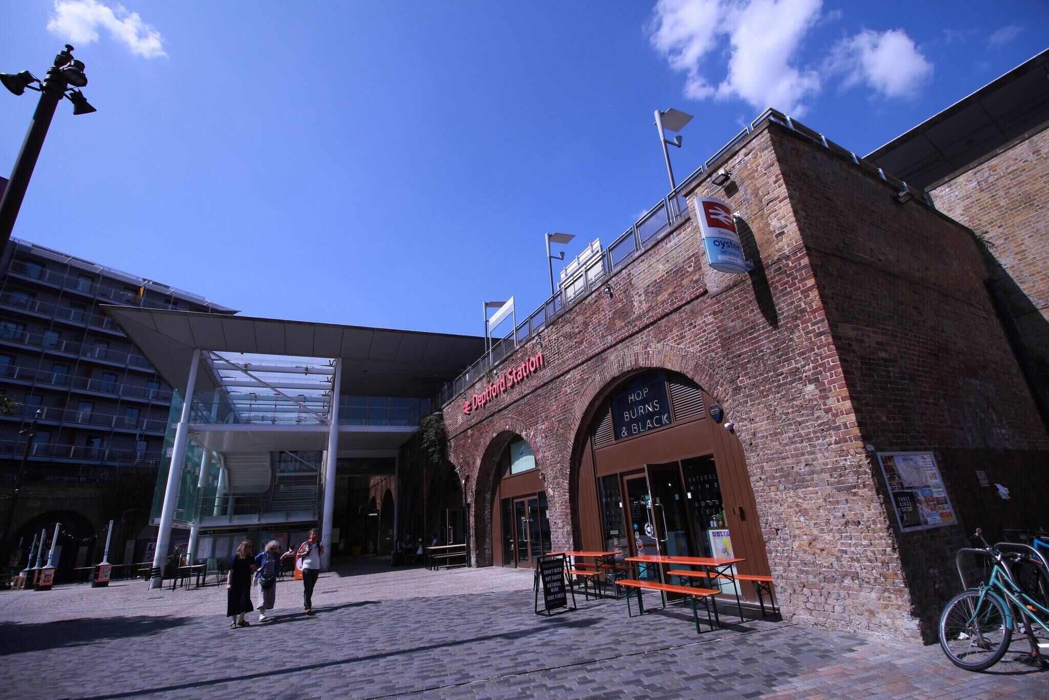 A building with a sign reading 'Deportation Station' and a restaurant named 'Hop Burns & Black.'