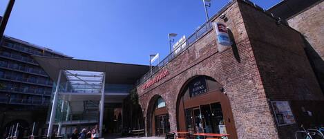 A building with a sign reading 'Deportation Station' and a restaurant named 'Hop Burns & Black.'