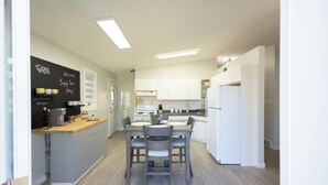 A modern kitchen with a central island, white cabinetry, and a chalkboard with writing. - Lakeview Escape at Gimli by Guest Expertise (gimli)