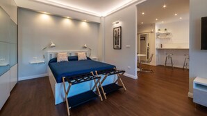 Een moderne slaapkamer met een bed, bedlampjes, een bureau en een stoel.