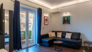 Een moderne woonkamer met een modulaire bank, een klein rond tafeltje en een schuifdeur naar een buitenruimte.