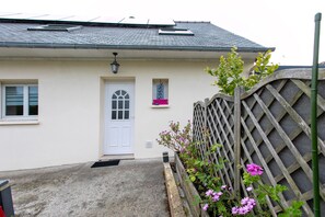 A house with a white exterior, a grey roof, a white door, and a small window with a decorative item above it. - Bed and Breakfast 'Chez Lydie' with Shared Terrace, Shared Garden and Wi-Fi (Binic-Étables-sur-Mer)
