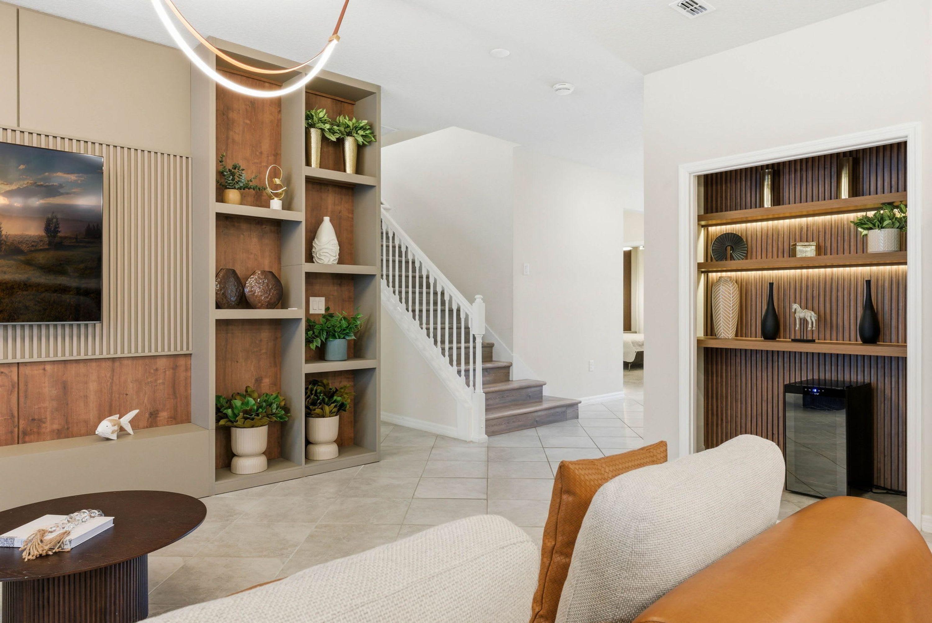 Un salon moderne avec un canapé, une table basse et un escalier menant à un autre niveau.