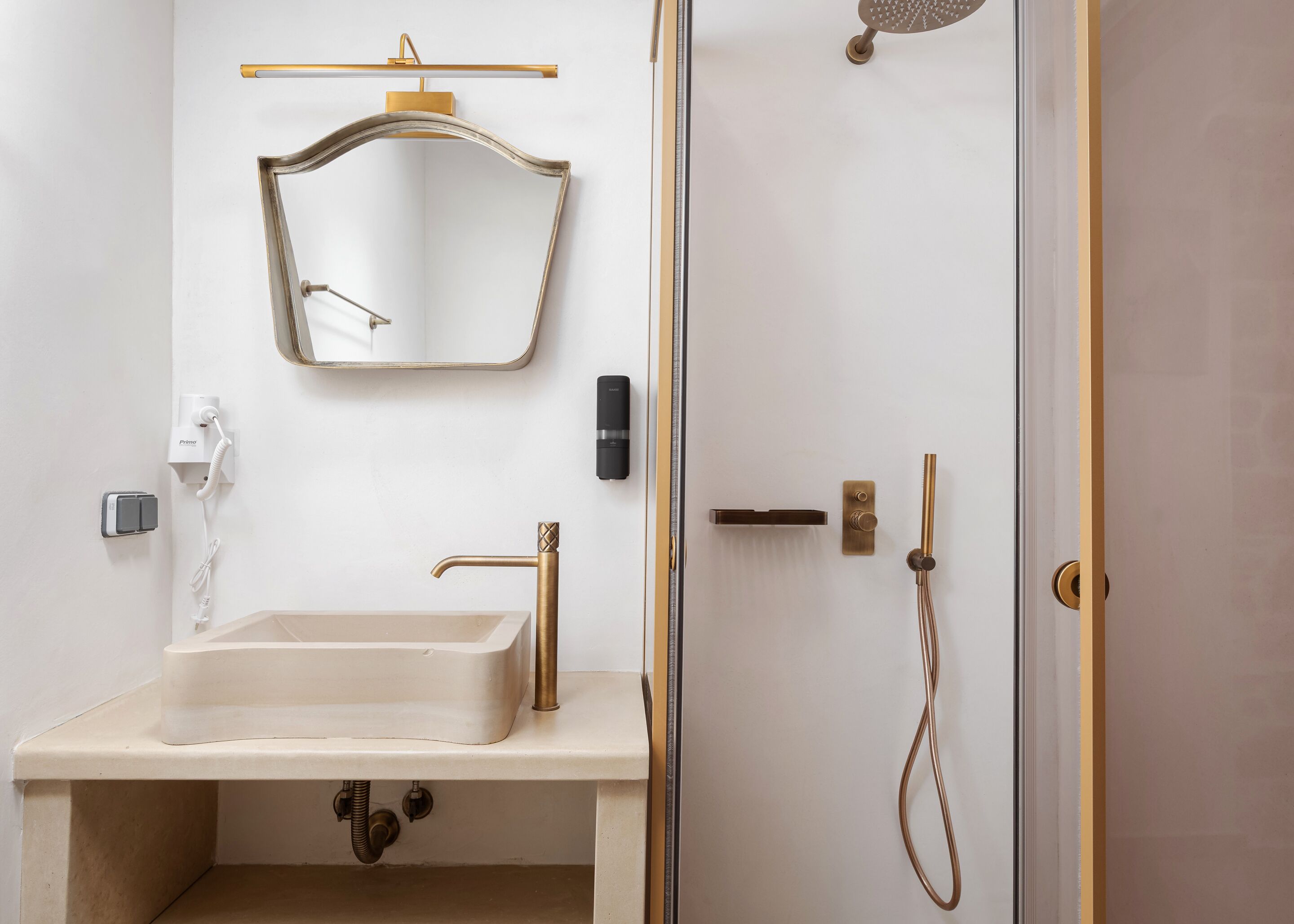 Un baño con lavamanos, espejo y ducha.