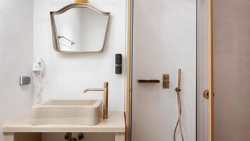Un baño con lavamanos, espejo y ducha.