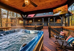 Ein Whirlpool auf einer Holzterrasse mit Stühlen und einem Fernsehbildschirm.