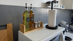 Una encimera de cocina con dos botellas de aceite, un dispensador de toallas de papel y un microondas.