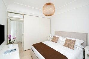 Une chambre d’hôtel comprenant un lit, des tables de chevet, une télévision et une armoire.