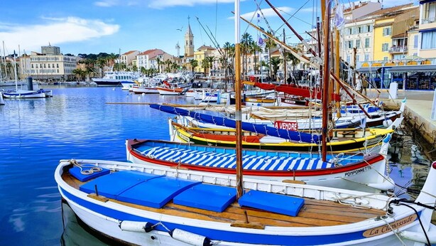 A marina with boats docked, a clear sky, and buildings in the background. - A haven of peace. Ground floor of a villa near the harbor with a private garden and entrance (Sanary-sur-Mer)