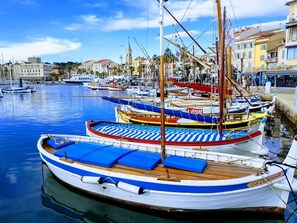 A marina with boats docked, a clear sky, and buildings in the background. - A haven of peace. Ground floor of a villa near the harbor with a private garden and entrance (Sanary-sur-Mer)