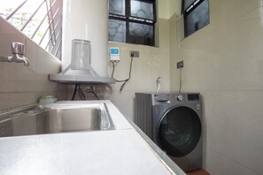 A laundry area with a washing machine, a sink, and a window. - Comfort Suite 2-Bed Apartment in Westlands, next to Mövenpick Nairobi Hotel (Nairobi)