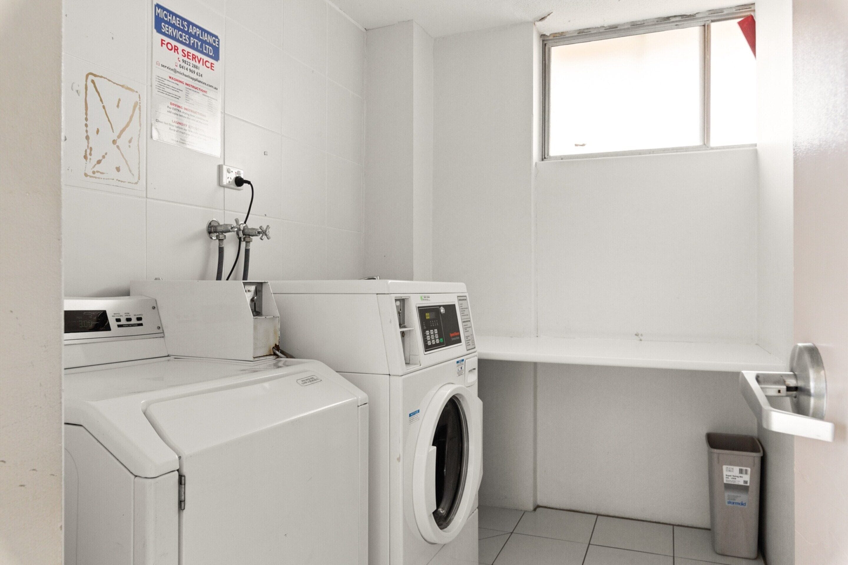 A laundry room with a washing machine, dryer, and a utility sink.