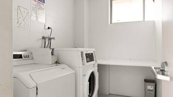 A laundry room with a washing machine, dryer, and a utility sink.