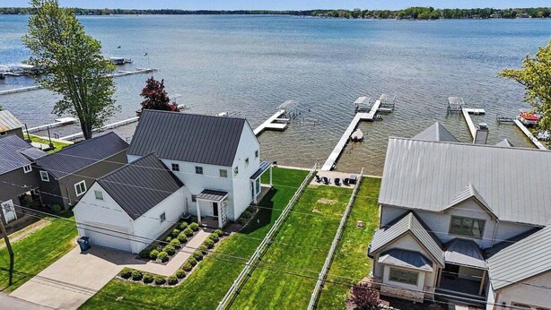 Ett bostadsområde med hus, en brygga och en sjö.