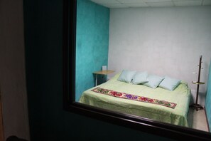 Ein Schlafzimmer mit Bett, Kissen, Nachttisch und Beistelltisch.